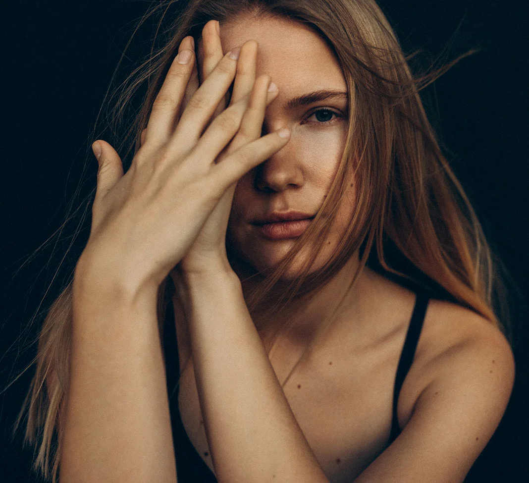 Close up of a woman's face as she holds her hands in front of her | Dermal Fillers | NYC