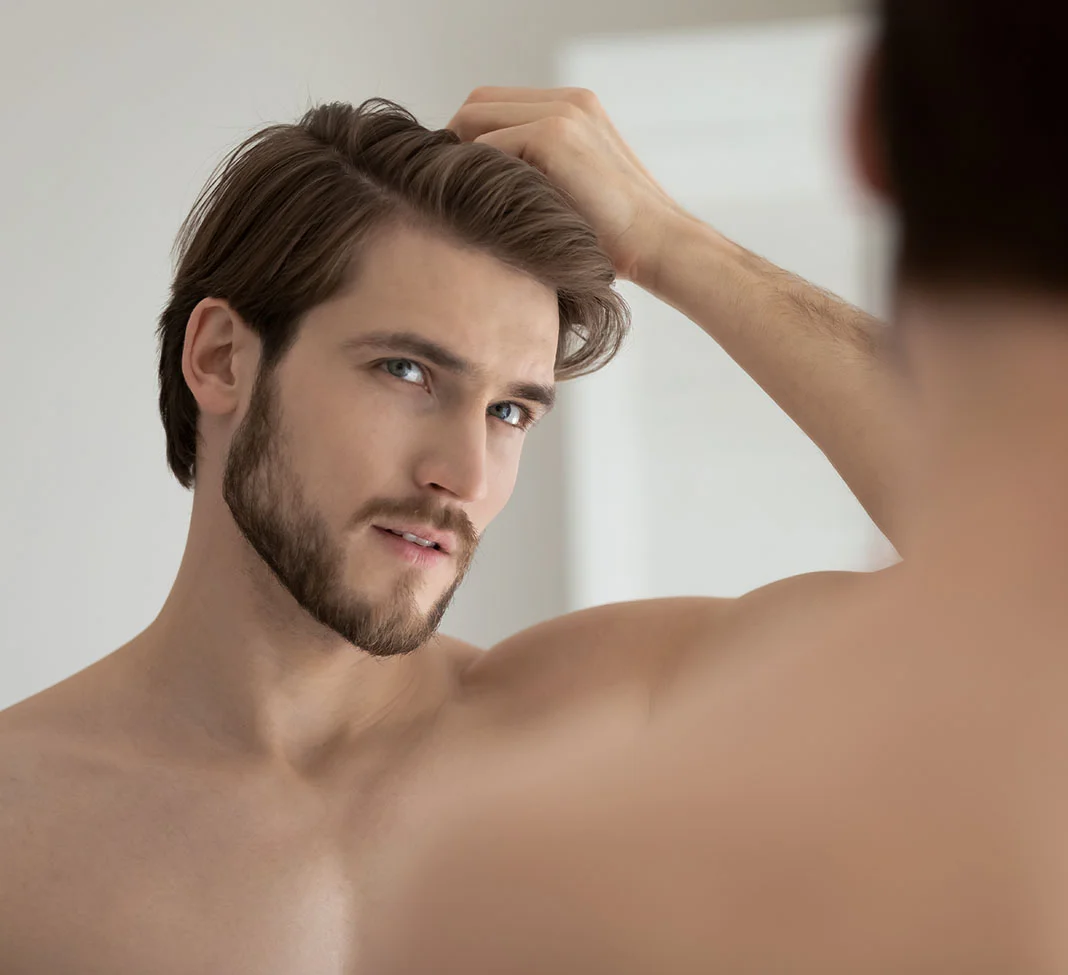 Man looking in the mirror at his hair line | Smart Graft | NYC